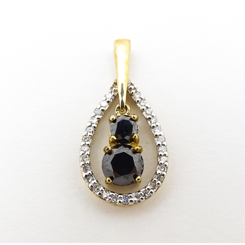 628 - A 9ct gold pendant set with banded diamonds and central dark coloured stones. Approx. 7/8