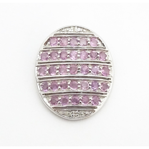 638 - A 9ct white gold pendant of oval form set with diamonds and pink sapphires. Approx. 7/8