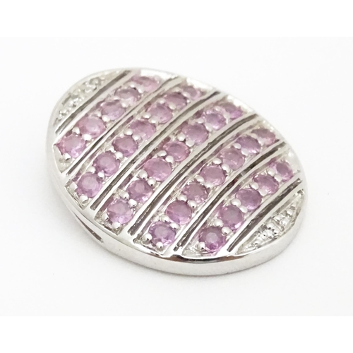 638 - A 9ct white gold pendant of oval form set with diamonds and pink sapphires. Approx. 7/8