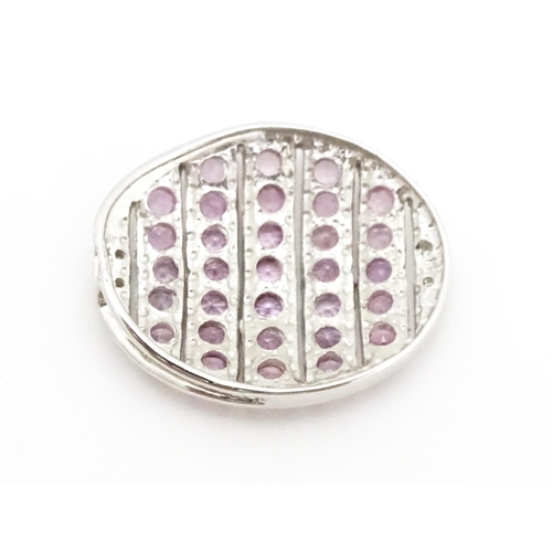 638 - A 9ct white gold pendant of oval form set with diamonds and pink sapphires. Approx. 7/8