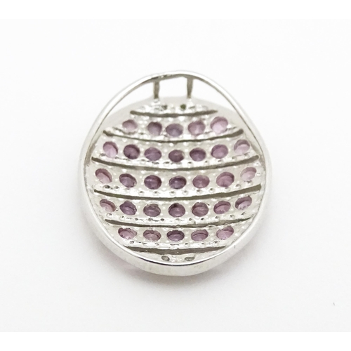 638 - A 9ct white gold pendant of oval form set with diamonds and pink sapphires. Approx. 7/8