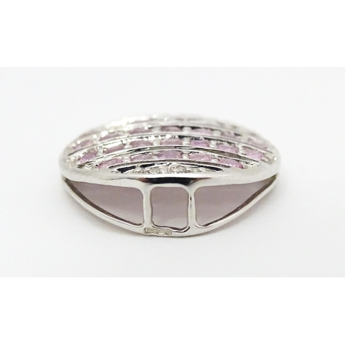 638 - A 9ct white gold pendant of oval form set with diamonds and pink sapphires. Approx. 7/8