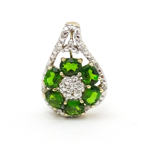 645 - A 9ct gold pendant set with diamonds and green stones. Approx. 3/4