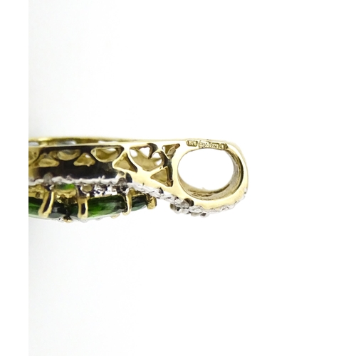 645 - A 9ct gold pendant set with diamonds and green stones. Approx. 3/4