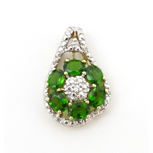 645 - A 9ct gold pendant set with diamonds and green stones. Approx. 3/4