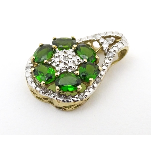 645 - A 9ct gold pendant set with diamonds and green stones. Approx. 3/4