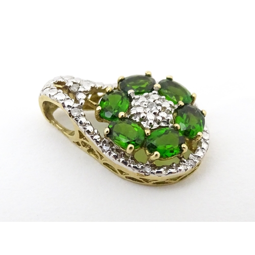 645 - A 9ct gold pendant set with diamonds and green stones. Approx. 3/4