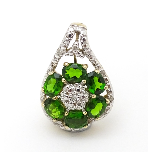 645 - A 9ct gold pendant set with diamonds and green stones. Approx. 3/4