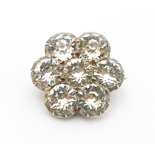 646 - A white metal brooch set with white paste stones in a daisy setting. Approx. 3/4