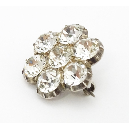 646 - A white metal brooch set with white paste stones in a daisy setting. Approx. 3/4