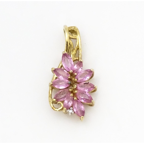 647 - A 9ct gold pendant set with pink sapphires and diamond. Approx. 1