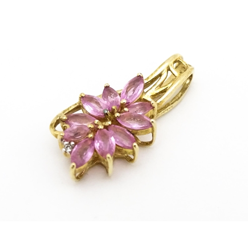 647 - A 9ct gold pendant set with pink sapphires and diamond. Approx. 1