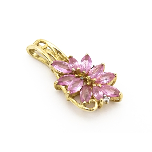 647 - A 9ct gold pendant set with pink sapphires and diamond. Approx. 1