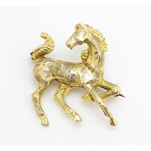 650 - A 9ct gold brooch modelled as a prancing horse / pony. Approx. 1 1/2