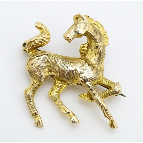 650 - A 9ct gold brooch modelled as a prancing horse / pony. Approx. 1 1/2