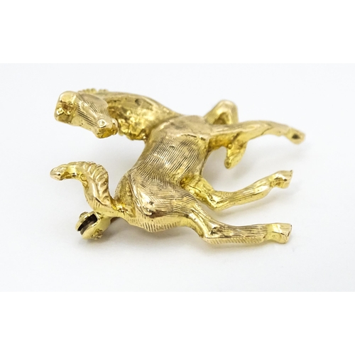 650 - A 9ct gold brooch modelled as a prancing horse / pony. Approx. 1 1/2