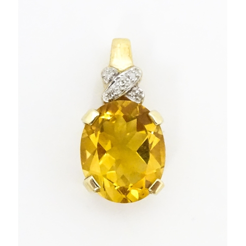 655 - A 9ct gold pendant set with oval citrine surmounted by diamonds. Approx. 3/4