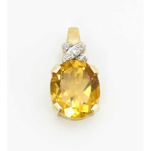 655 - A 9ct gold pendant set with oval citrine surmounted by diamonds. Approx. 3/4