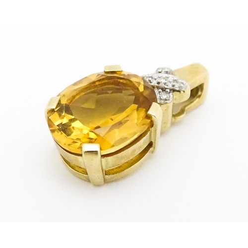 655 - A 9ct gold pendant set with oval citrine surmounted by diamonds. Approx. 3/4