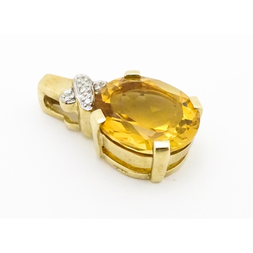 655 - A 9ct gold pendant set with oval citrine surmounted by diamonds. Approx. 3/4