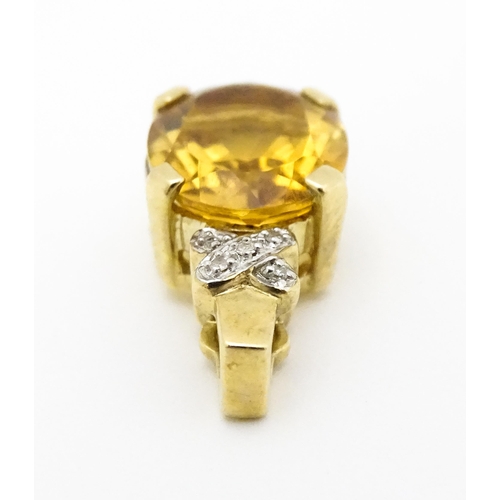 655 - A 9ct gold pendant set with oval citrine surmounted by diamonds. Approx. 3/4