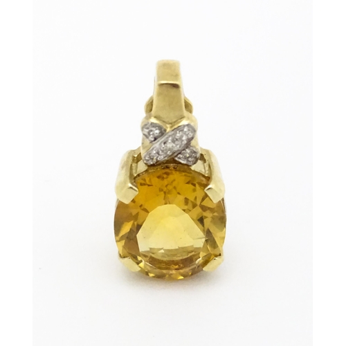 655 - A 9ct gold pendant set with oval citrine surmounted by diamonds. Approx. 3/4