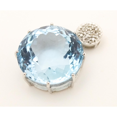 665 - A 9ct white gold pendant set with topaz and diamonds. Approx. 1 1/4