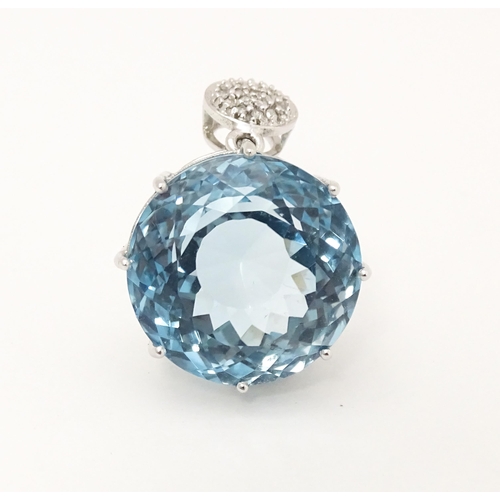 665 - A 9ct white gold pendant set with topaz and diamonds. Approx. 1 1/4