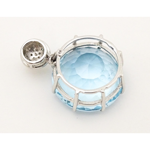 665 - A 9ct white gold pendant set with topaz and diamonds. Approx. 1 1/4