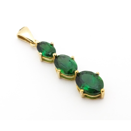 670 - A 9ct gold pendant set with three graduated green stones. Approx. 1 1/42 long