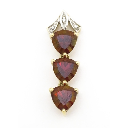 675 - A 9ct gold pendant set with cherry topaz and diamonds. Approx. 1 1/2