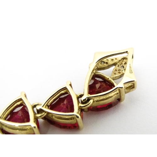 675 - A 9ct gold pendant set with cherry topaz and diamonds. Approx. 1 1/2