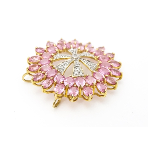 680 - A 9ct gold pendant set with diamonds and pink sapphires. Approx. 1 1/4