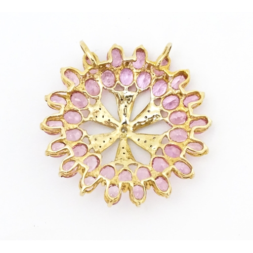 680 - A 9ct gold pendant set with diamonds and pink sapphires. Approx. 1 1/4