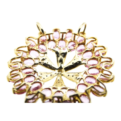 680 - A 9ct gold pendant set with diamonds and pink sapphires. Approx. 1 1/4