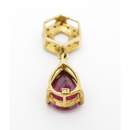 685 - A 9ct gold pendant set with diamonds and red stone drop. Approx. 1