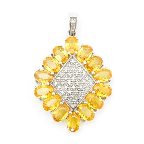 698 - A 9ct white gold pendant set with diamonds and yellow stones. Approx. 1 1/2