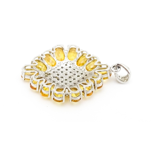 698 - A 9ct white gold pendant set with diamonds and yellow stones. Approx. 1 1/2