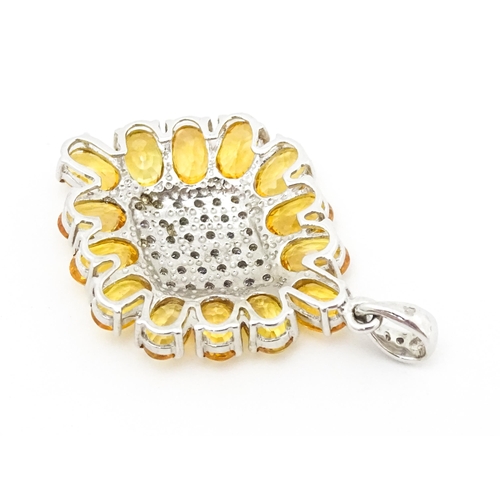 698 - A 9ct white gold pendant set with diamonds and yellow stones. Approx. 1 1/2