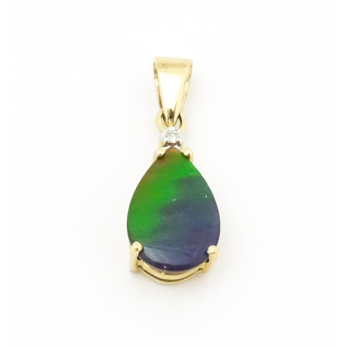 700 - A 9ct gold pendant set with ammolite and diamonds. Approx. 3/4