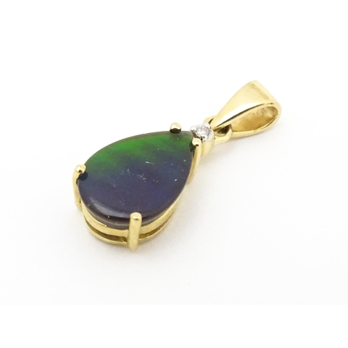 700 - A 9ct gold pendant set with ammolite and diamonds. Approx. 3/4