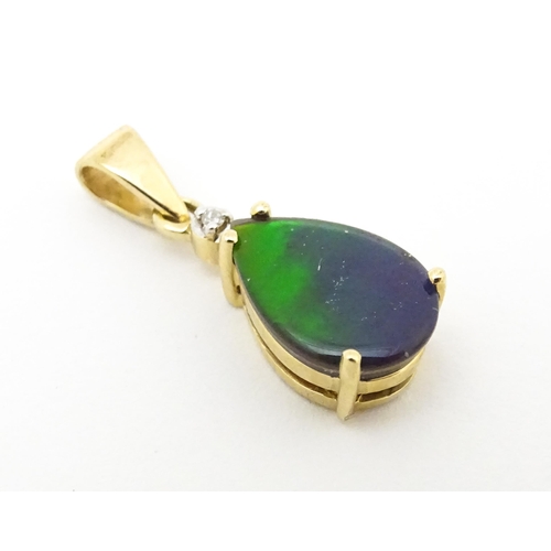 700 - A 9ct gold pendant set with ammolite and diamonds. Approx. 3/4