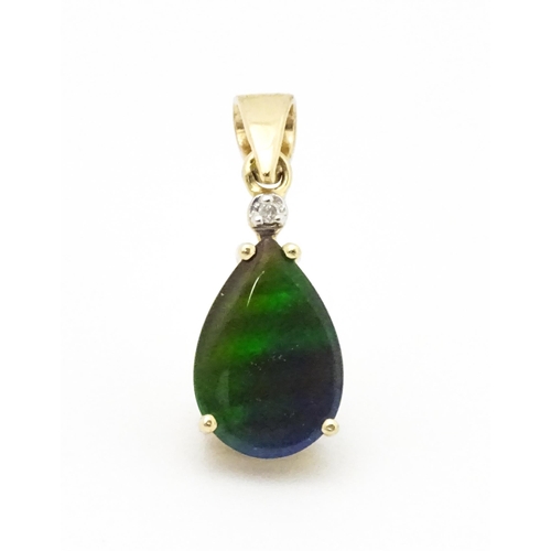 700 - A 9ct gold pendant set with ammolite and diamonds. Approx. 3/4