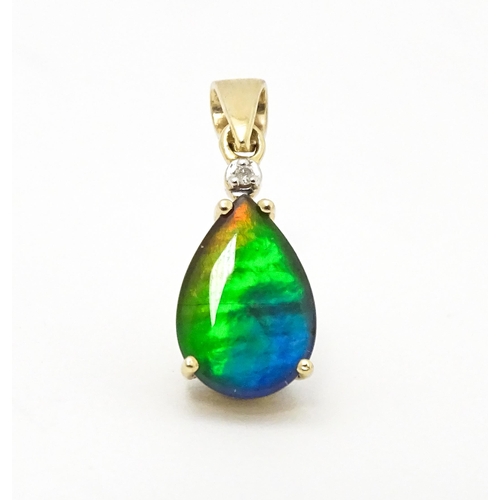 700 - A 9ct gold pendant set with ammolite and diamonds. Approx. 3/4