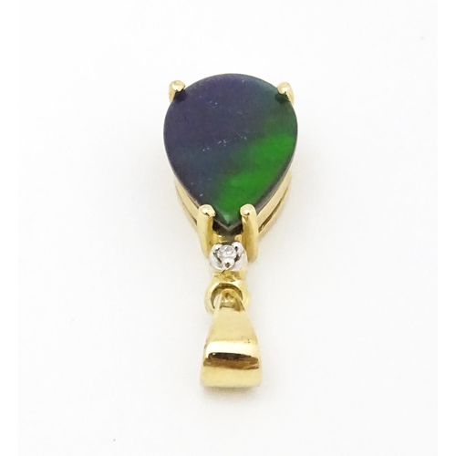 700 - A 9ct gold pendant set with ammolite and diamonds. Approx. 3/4