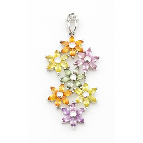 702 - A 9ct white gold pendant set with diamonds and coloured floral detail. Approx. 2