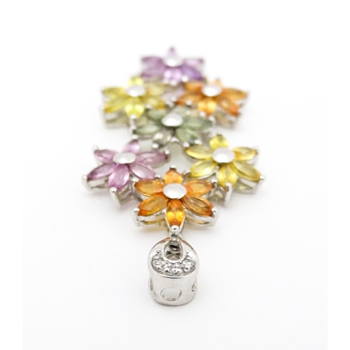 702 - A 9ct white gold pendant set with diamonds and coloured floral detail. Approx. 2