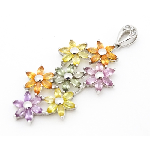 702 - A 9ct white gold pendant set with diamonds and coloured floral detail. Approx. 2