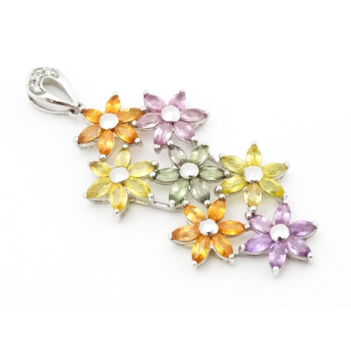 702 - A 9ct white gold pendant set with diamonds and coloured floral detail. Approx. 2