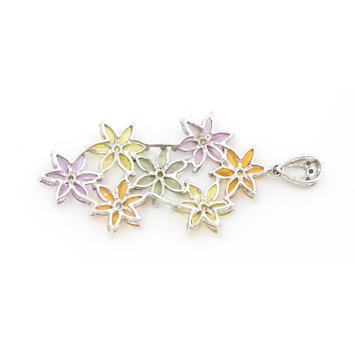 702 - A 9ct white gold pendant set with diamonds and coloured floral detail. Approx. 2